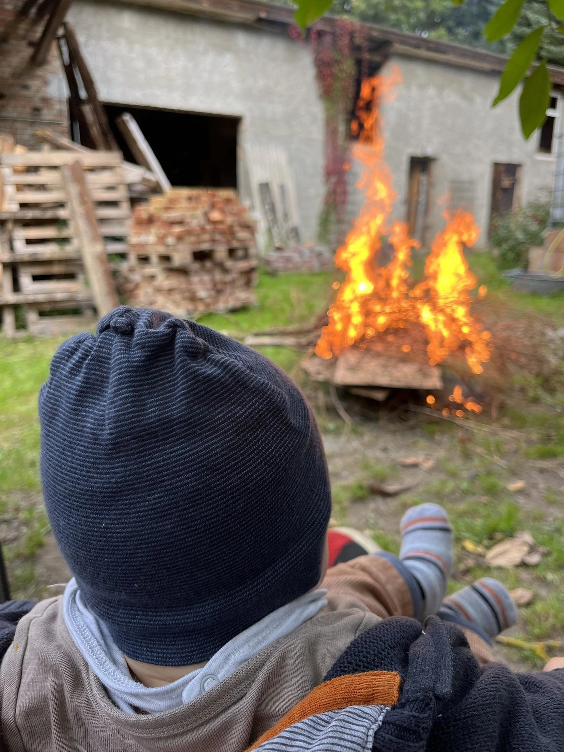 Hof Drögemühle - Landwirtschaft - Person sitzt in der Nähe von Feuer